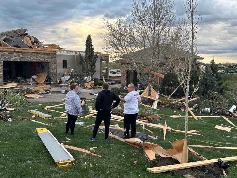 Homeowners assess damage after a tornado caused extensive damage in their neighborhood northwest of Omaha in Bennington, Neb.