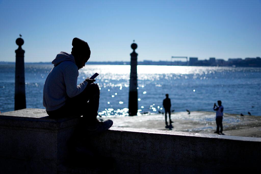 teen on phone at dock