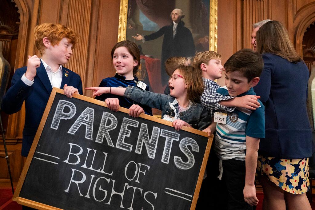 Children play with a chalkboard sign as Speaker of the House Kevin McCarthy, right, speaks with a parent after an event about proposed legislation dubbed the "Parents Bill of Rights"