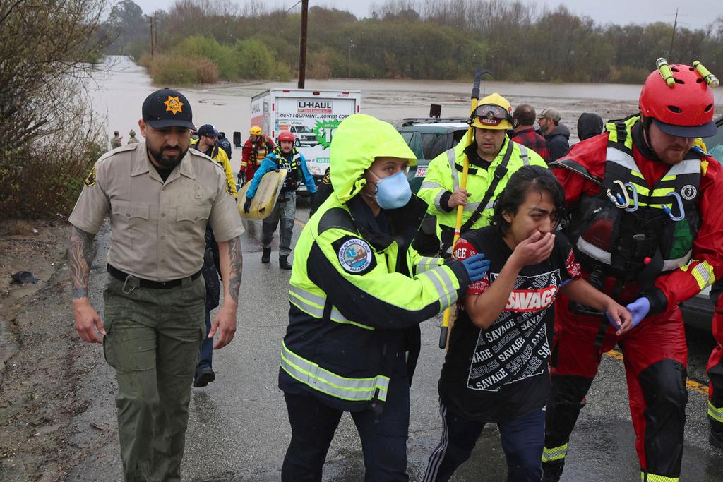 Lizbeth Hernandez is rescued from Casserly Creek after flood waters carried her truck off of Paulsen Road in Watsonville, Calif., Friday, March 10, 2023. 