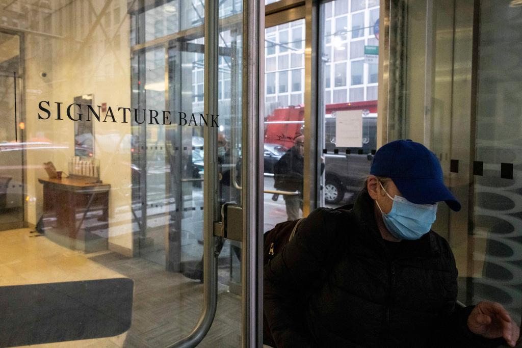 A person leaves one of the Signature Bank branches in New York