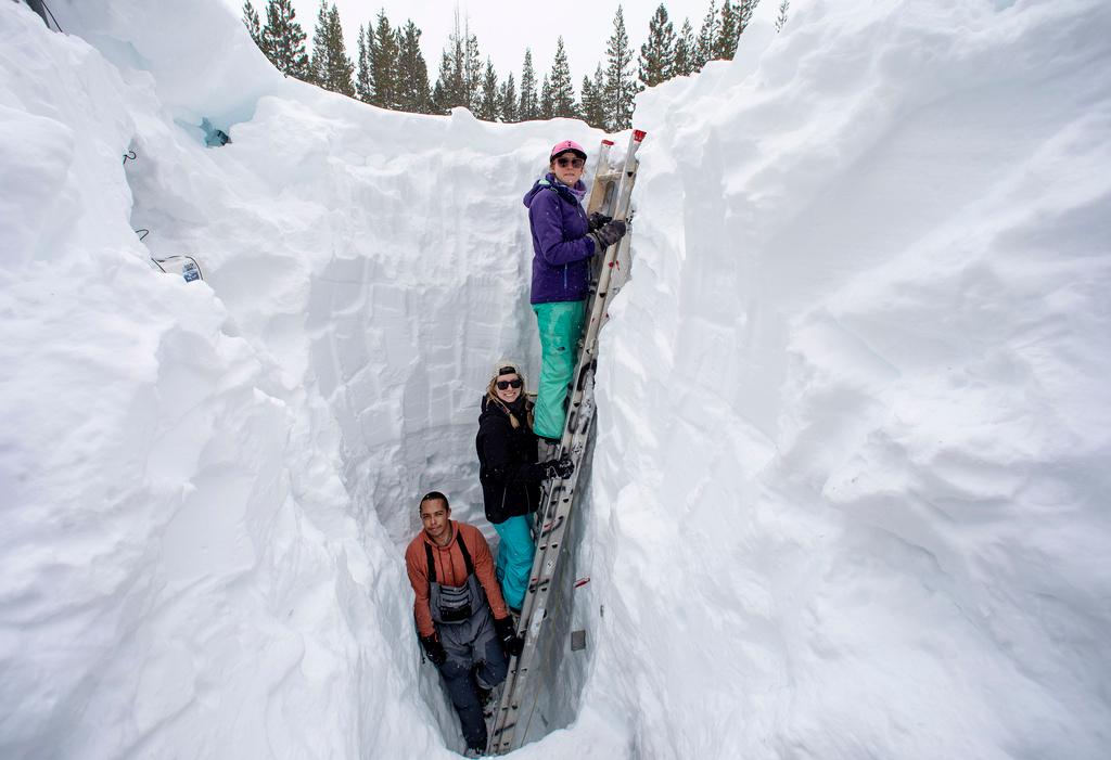 Working inside a nearly 18-foot-deep snow pit at the UC Berkeley Central Sierra Snow Lab, from left, Shaun Joseph, Claudia Norman, Helena Middleton take measurements of snow temperatures ahead of a Pacific storm 