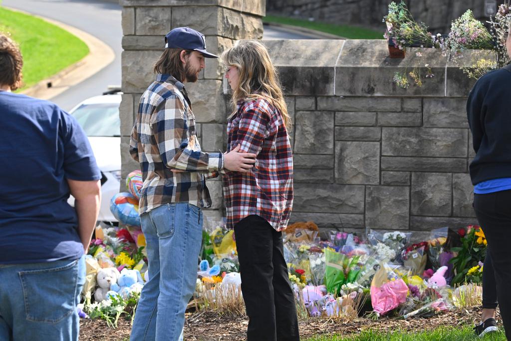 People console each other at an entry to Covenant School in Nashville, Tenn.