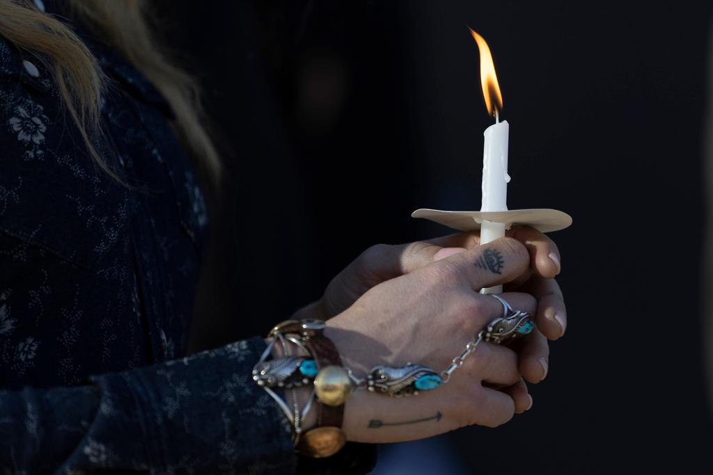 A woman holds a candle during a vigil held for victims of The Covenant School shooting on Wednesday, March 29, 2023, in Nashville