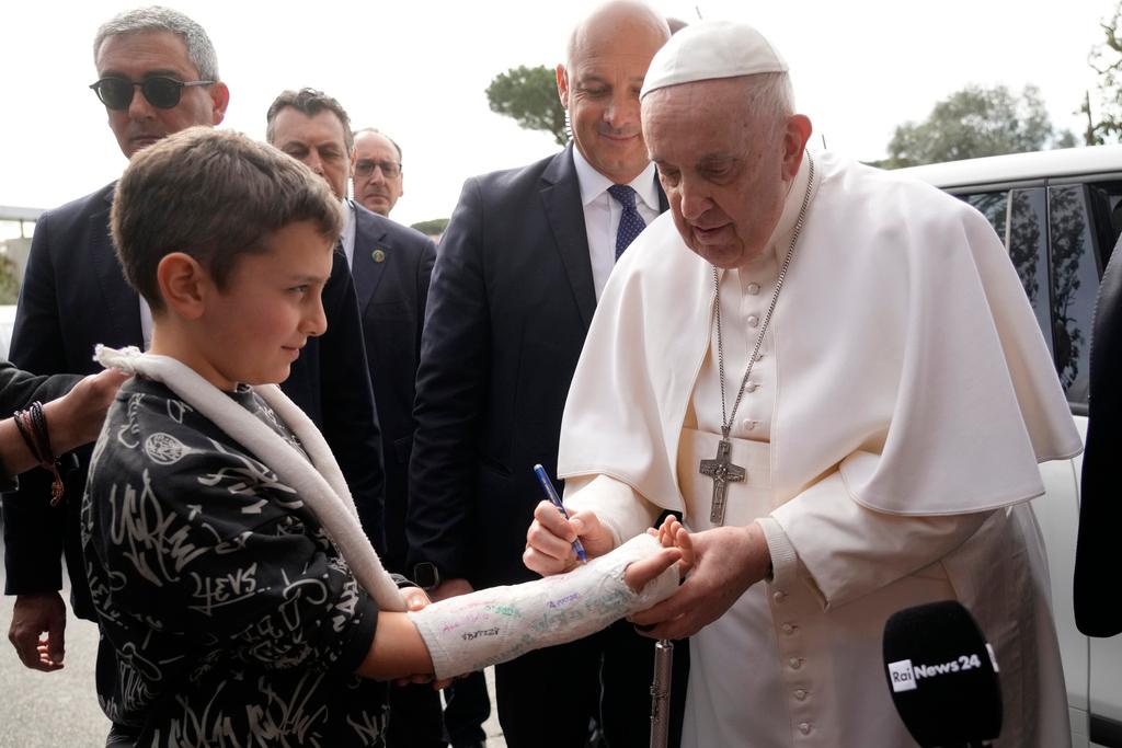 Pope Francis autographs the plaster cast of a child as he leaves the Agostino Gemelli University Hospital in Rome, Saturday, April 1, 2023, after receiving treatment for bronchitis, The Vatican said. Francis was hospitalized on Wednesday after his public general audience in St. Peter's Square at The Vatican.