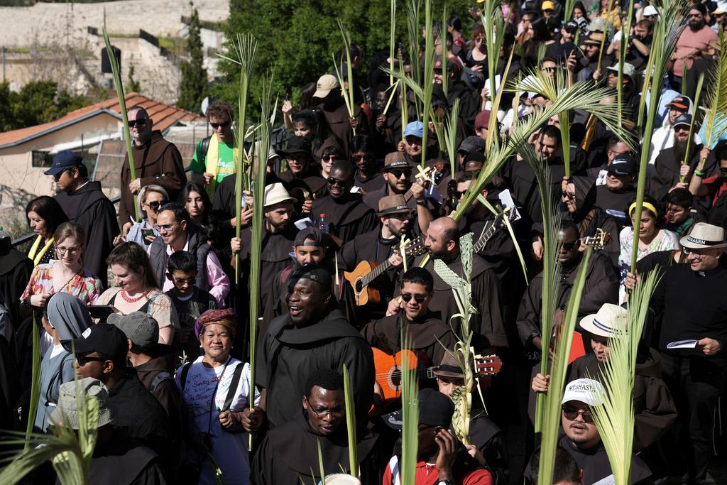 Christians walk in the Palm Sunday procession on the Mount of Olives in east Jerusalem, Sunday, April 2, 2023. 