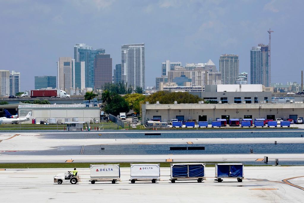 A Delta baggage train drives on the closed runway at Fort Lauderdale-Hollywood International Airport Friday, April 14, 2023, in Fort Lauderdale, Fla.