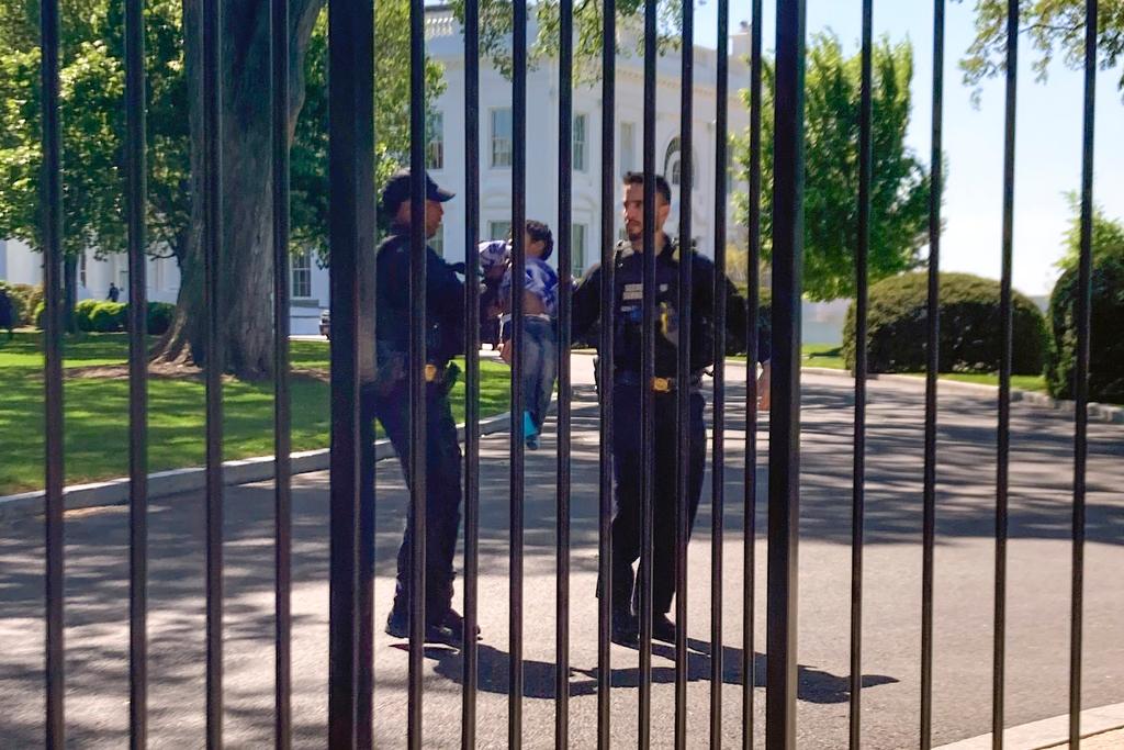 U.S. Secret Service uniformed division police officers carry a young child who crawled through the White House fence