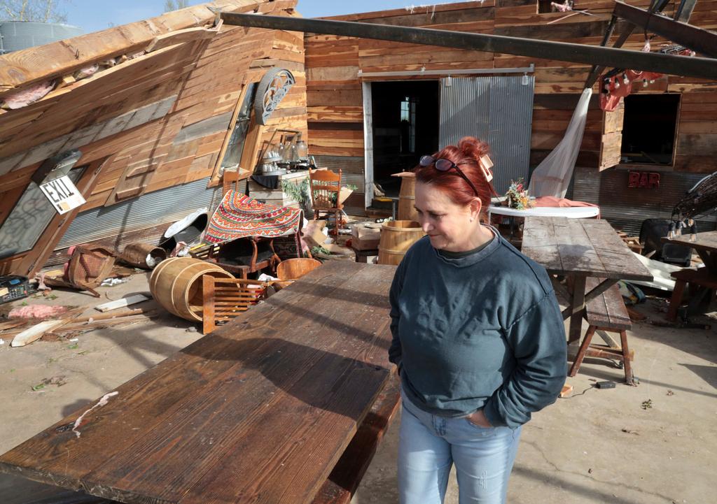 Kimber Hendrickson surveys damage from tornado sustained by her Scissortail Silos wedding venue in Cole, Okla. Hendrickson had a wedding scheduled Saturday and is currently trying to contact around 40 brides with the news.