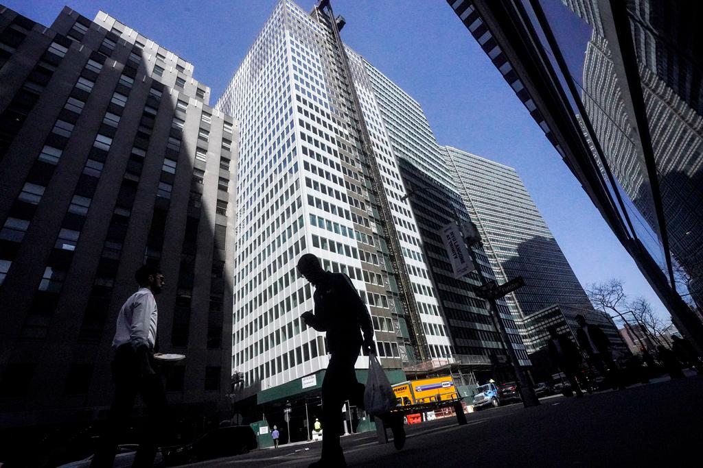 A pedestrian is silhouetted against a high rise at 160 Water Street in Manhattan's financial district, as the building is undergoing a conversion to residential apartments