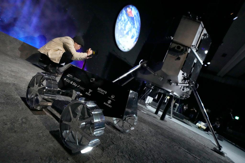 A photographer shoots the models of the lander and the lunar rover of HAKUTO-R private lunar exploration program