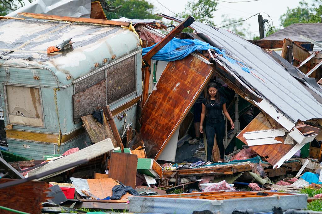 A person stands outside of a damaged home after a tornado hit Saturday, May 13, 2023, in the unincorporated community of Laguna Heights, Texas