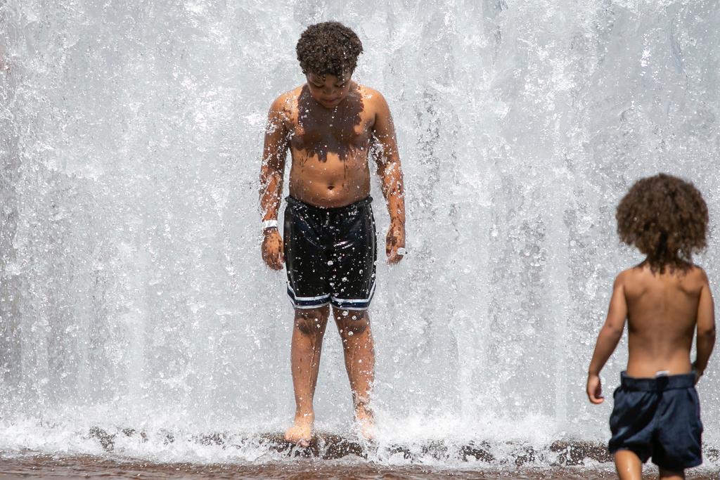 Children cool off in the Salmon Street Springs fountain in downtown Portland, Ore., as a spring heat wave sweeps across the metro area, Saturday, May 13, 2023. 