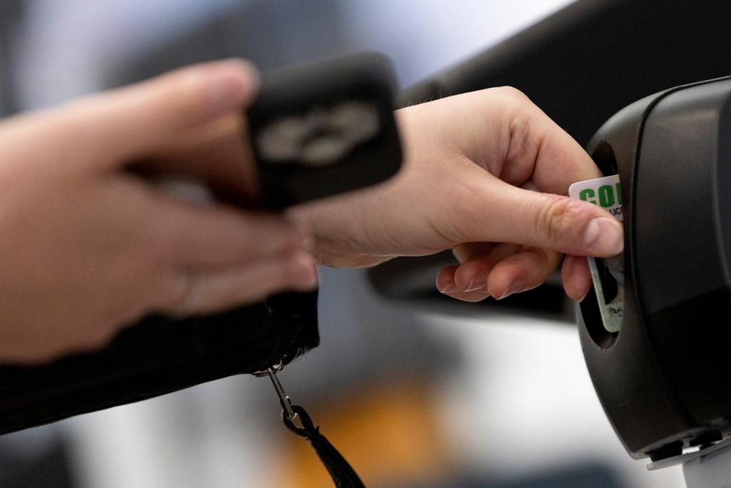 A traveler inserts her ID card while using the Transportation Security Administration's new facial recognition technology at a Baltimore-Washington International Thurgood Marshall Airport security checkpoint