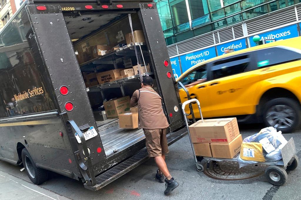 A United Parcel Service driver loads his truck, adjacent to a UPS Store, in New York