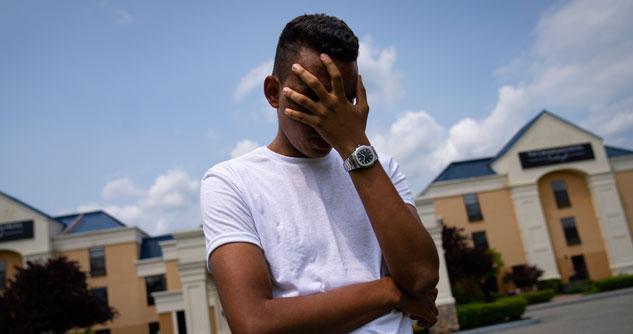 Teenager hiding his face