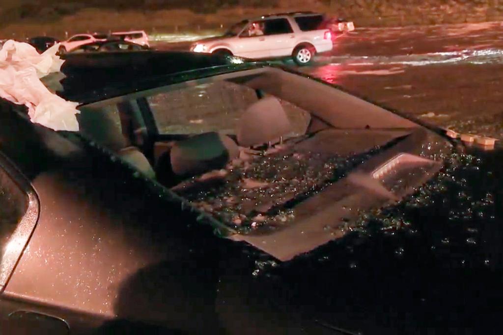 In this image taken from video, hail shatters a window on a vehicle during a storm at the Red Rocks Ampitheatre, Wednesday evening, June 21, 2023, in Morrison, Colo.