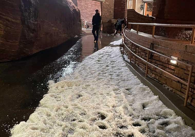 Hail covers a walkway at the Red Rocks Amphitheater in Morrison, Colo., near Denver