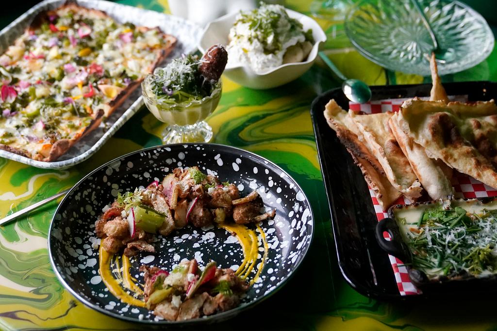 Multiple dishes are shown at a table at Shuggie's Trash Pie restaurant in San Francisco