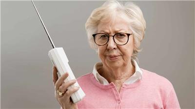 Older woman holds a cordless phone