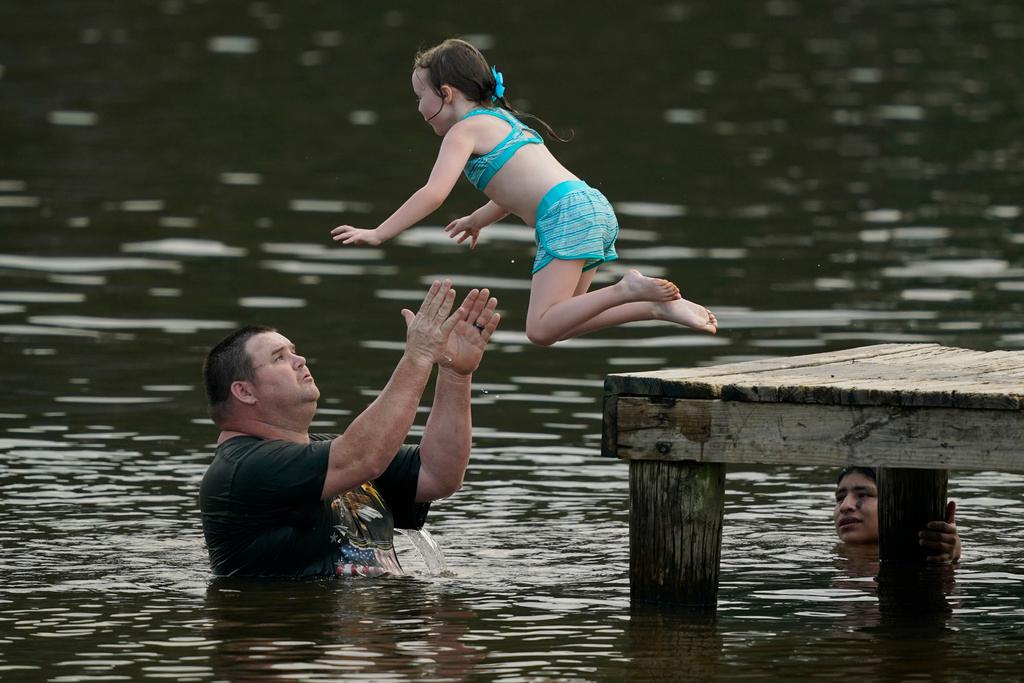 Beating the heat! John Crouch of Richland, helps Phoebe Sheffield, five, dive off the landing into the Ross Barnett Reservoir at Bobby Cleveland Park at Lakeshore in Rankin County, Miss.