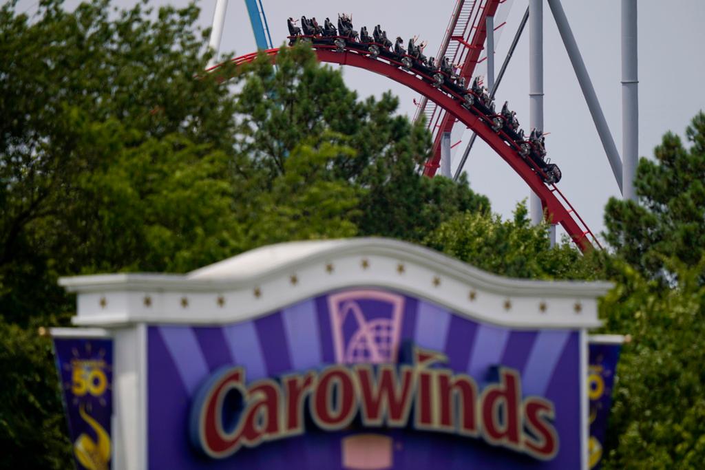 People ride a roller coaster at the Carowinds amusement park in Charlotte, N.C.