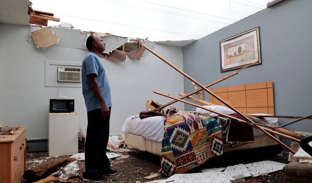 With the roof blown off by severe winds, Brian Patel, owner of the Skyline Motel in the suburban town of McCook, Ill., for the past 30 years, surveys storm damage in one of the motel rooms, Thursday, July 13, 2023.