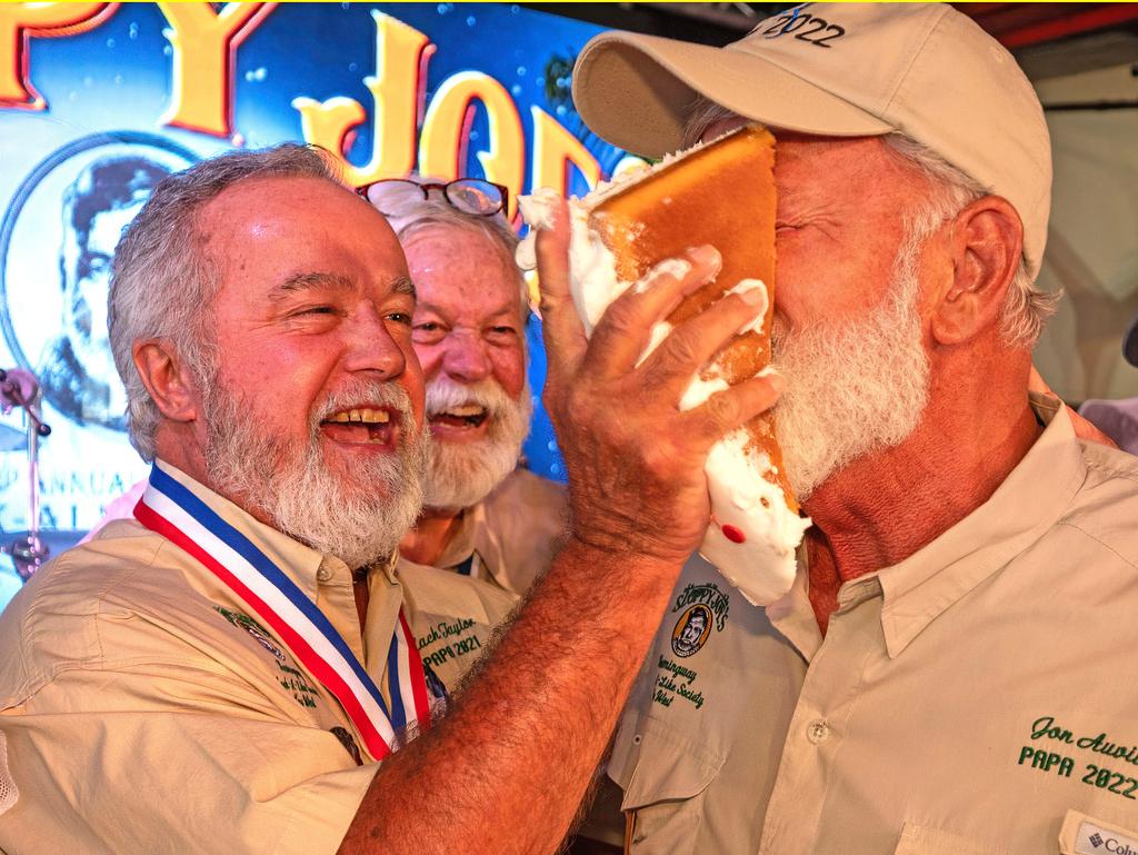 Zach Taylor, the 2021 "Papa" Hemingway Look-Alike Contest winner, shoves birthday cake into the face of 2022 winner Jon Auvil