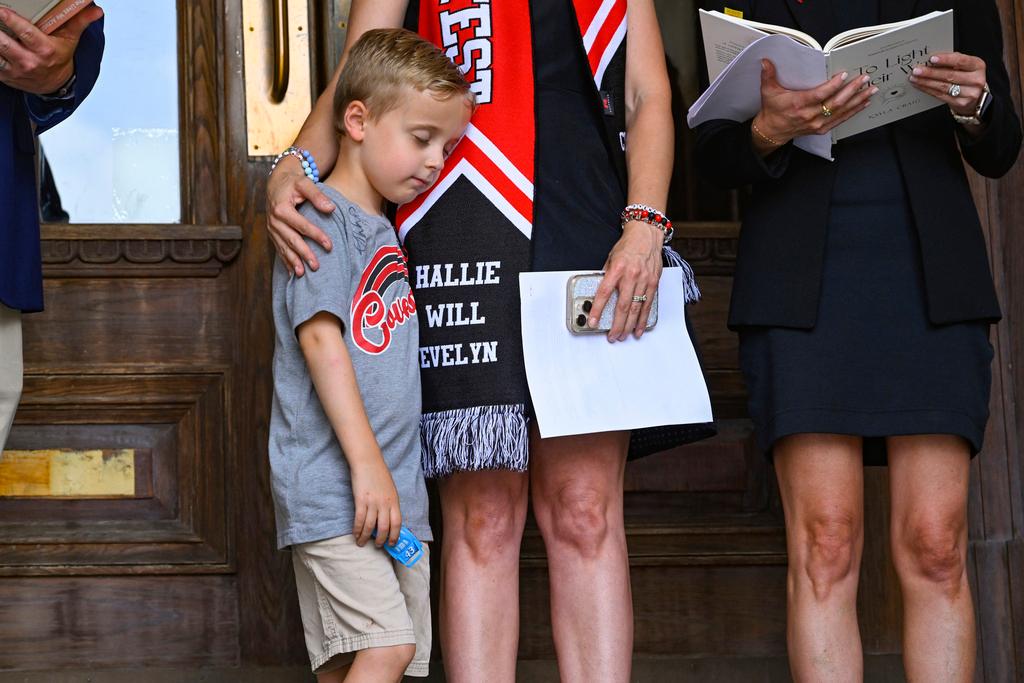 Noah Neumann, 6, is comforted by his Covenant mother as families engage in a prayer service leading up to a special session of the state legislature