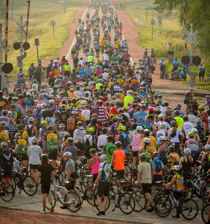 Riders, participating in RAGBRAI - the Register’s Annual Great Bicycle Ride Across Iowa- slow down to cross train tracks on the way out of Sioux City, Iowa