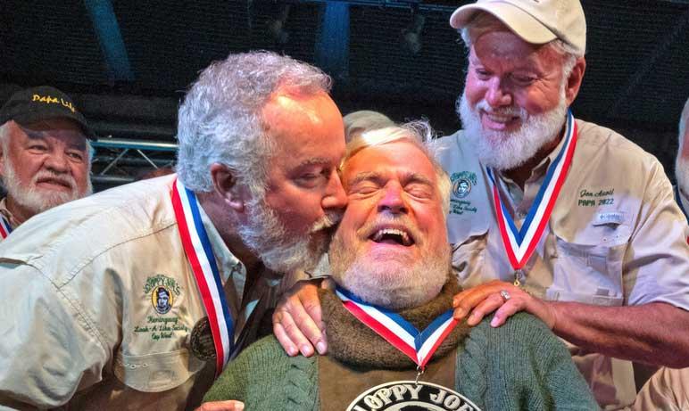 Zach Taylor, left, and Jon Auvil, right, congratulate Gerrit Marshall, center, for winning the annual Hemingway Look-Alike Contest