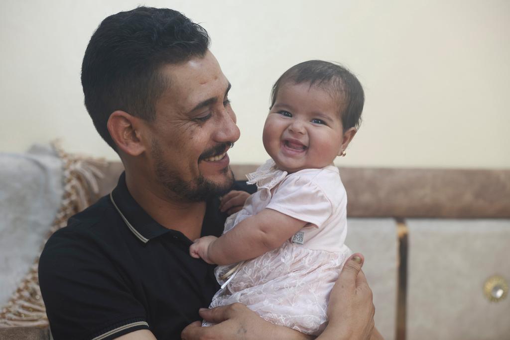 Khalil al-Sawadi plays with his adopted daughter Afraa in Jinderis, Syria