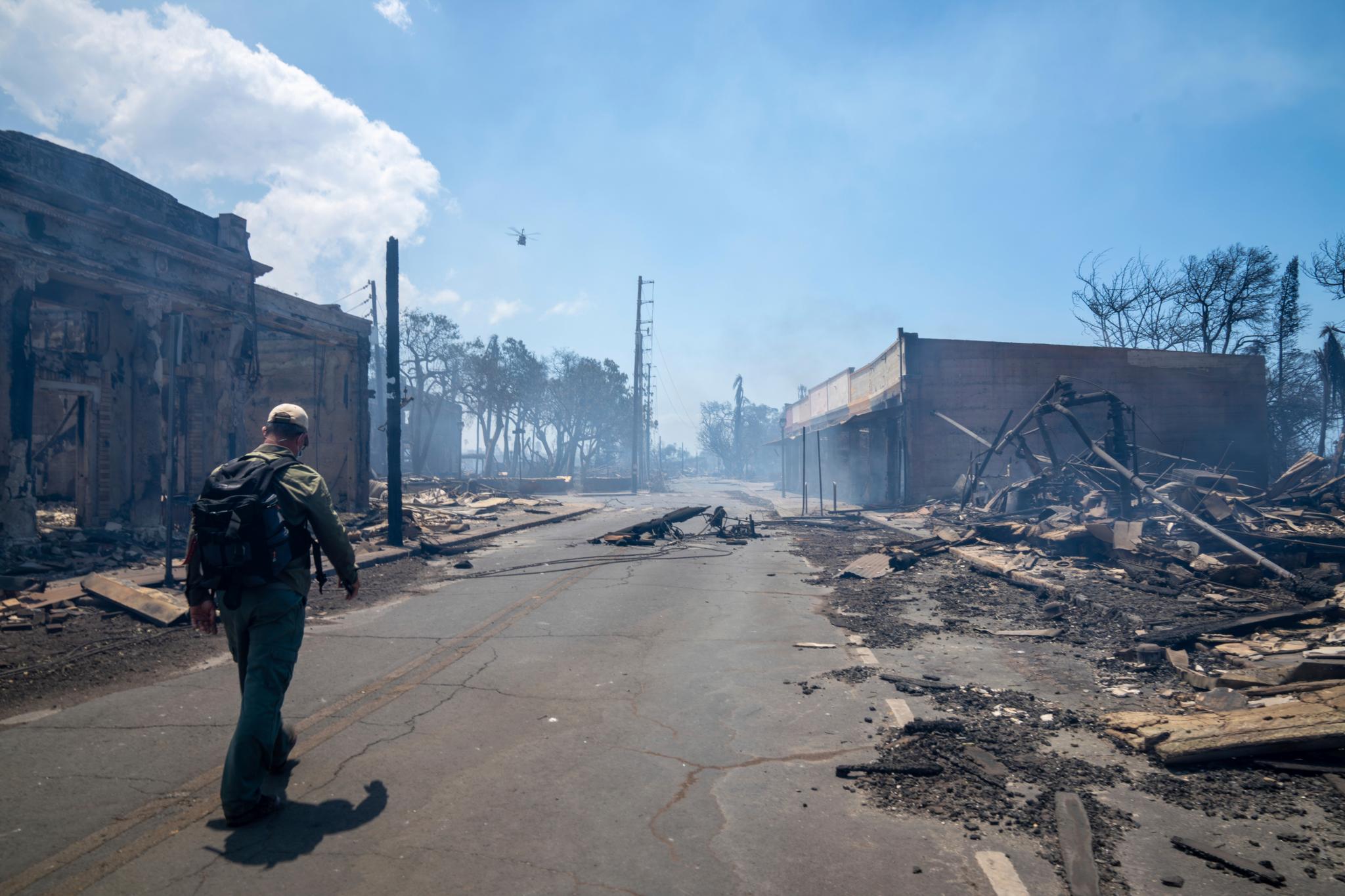 Man walks past wildfire wreckage in Lahaina, Hawaii