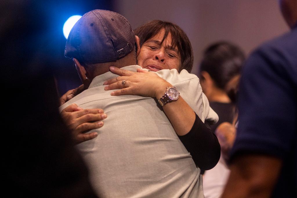 Believers embrace during a church service at King's Cathedral in Kahului on the island of Maui