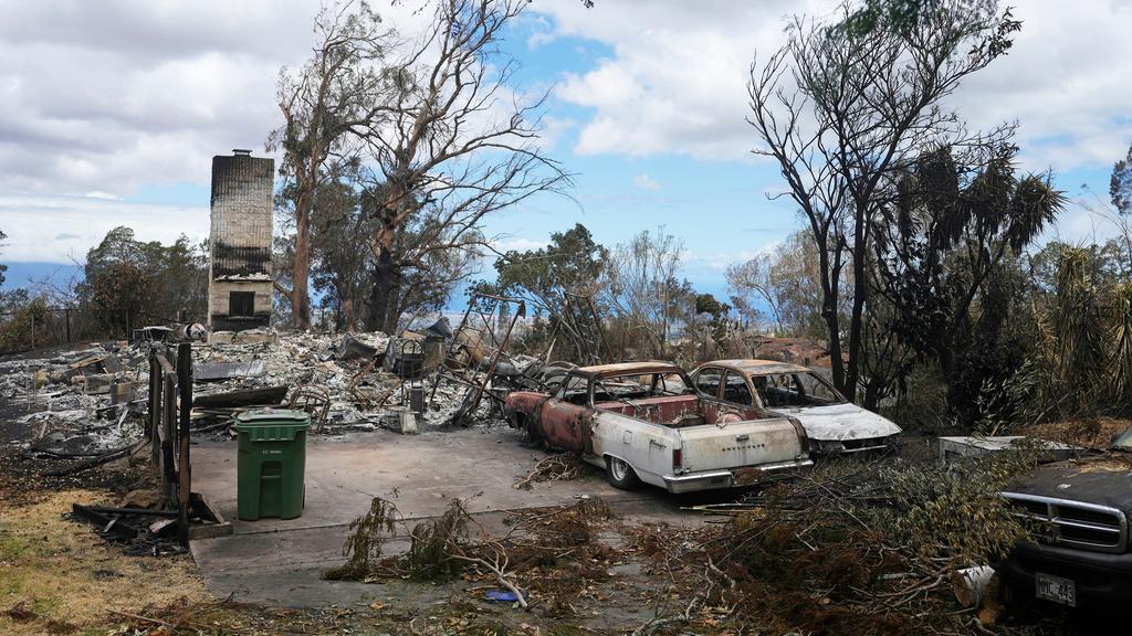 Charred vehicles sit near a wildfire-destroyed home in Kula, Hawaii. The same day a wildfire ripped through Lahaina, one tore through Kula, as well.