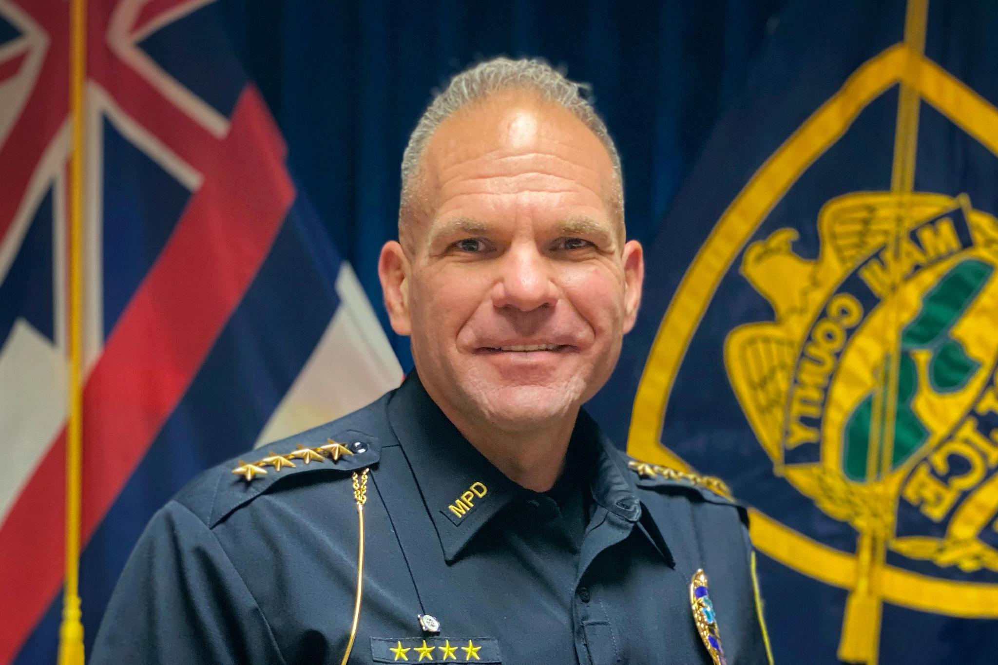 Police chief in front of a few flags