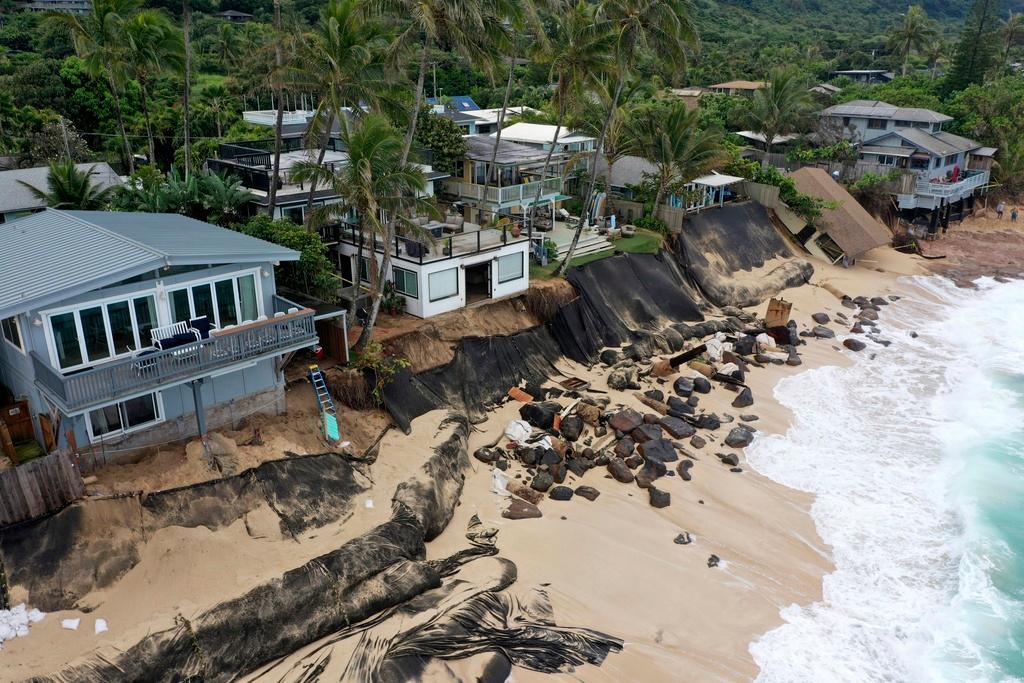  a home, right, after it collapsed onto a beach on Feb. 28, 2022, in Haleiwa, Hawaii.