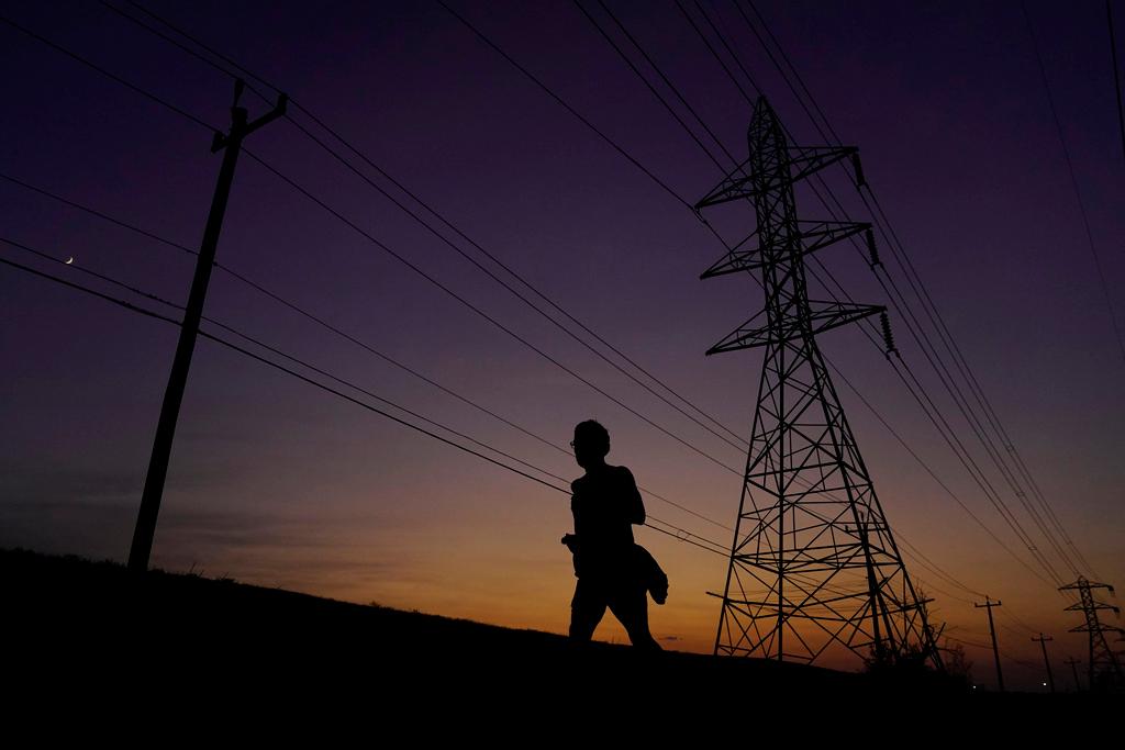 A sweaty jogger passes power lines during a sunset run in San Antonio.