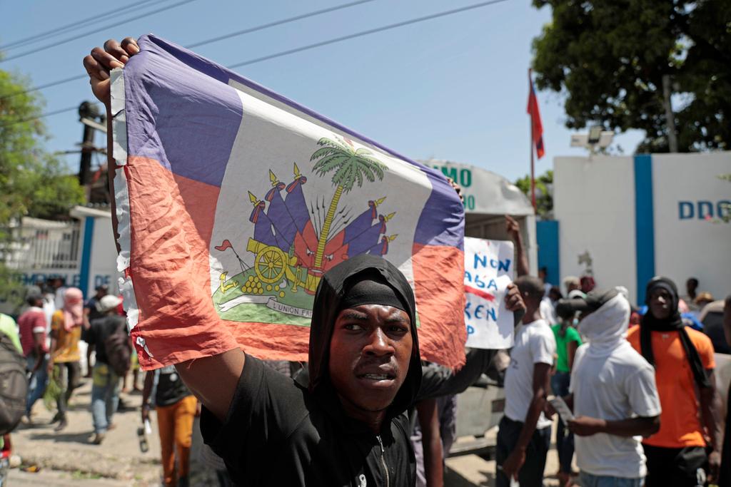 A demonstrator holds up a Haitian flag during a protest against insecurity 