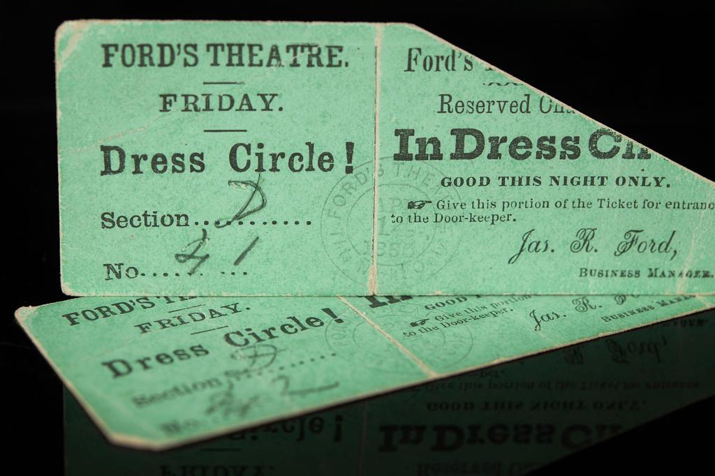 Rare front-row balcony tickets to Ford's Theatre on April 14, 1865 rest on a reflective surface. The tickets, dated when President Abraham Lincoln was assassinated by John Wilkes Booth