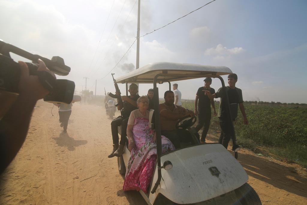 Palestinians transport a captured Israeli civilian from Kfar Azza kibbutz into the Gaza Strip 