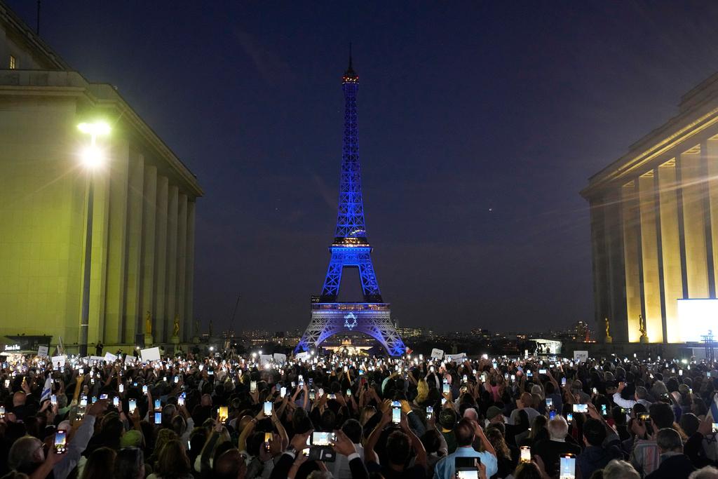 The Eiffel Tower is illuminated with the colors of Israel after a demonstration in a show of support for Israel