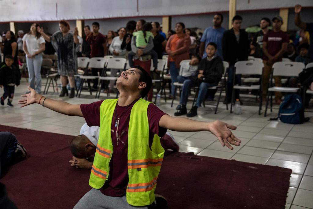 A Mexican migrant prays during a service at the "Embajadores de Jesus" Christian migrant shelter in Tijuana