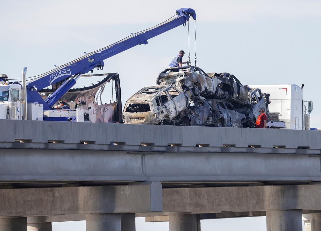 Workers remove heavily damaged vehicles from Interstate 55 near Manchac, La., Monday, Oct. 23, 2023.