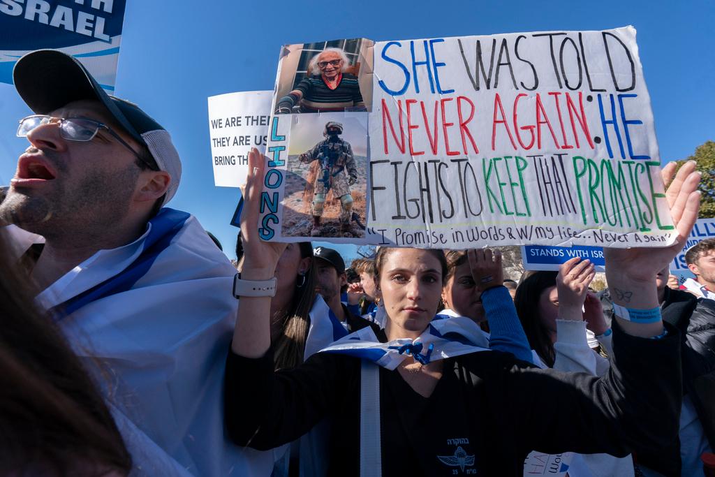 Talia Raab, holds up a picture of her grandmother, living holocaust survivor Edith Raab 98, during a March for Israel rally on the National Mall