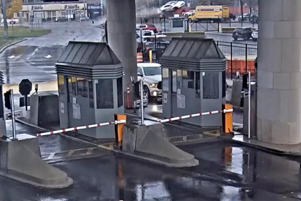 Image taken from security video, a light colored vehicle, top center, flies over a fence into the Rainbow Bridge customs plaza