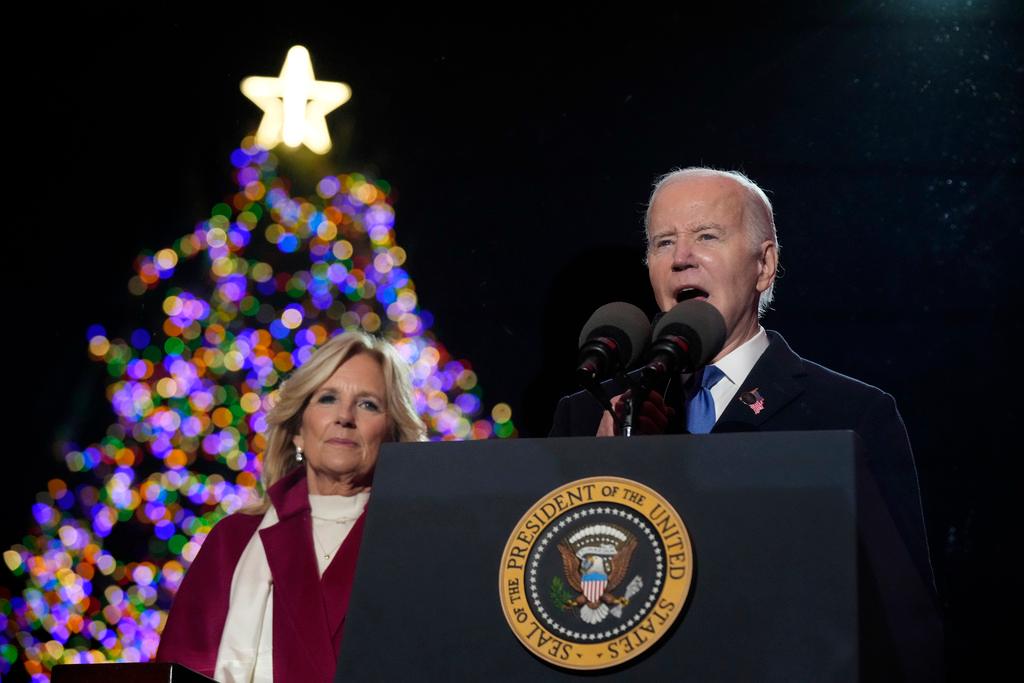 President Joe Biden speaks as first lady Jill Biden listen after they lit the National Christmas Tree on the Ellipse, near the White House