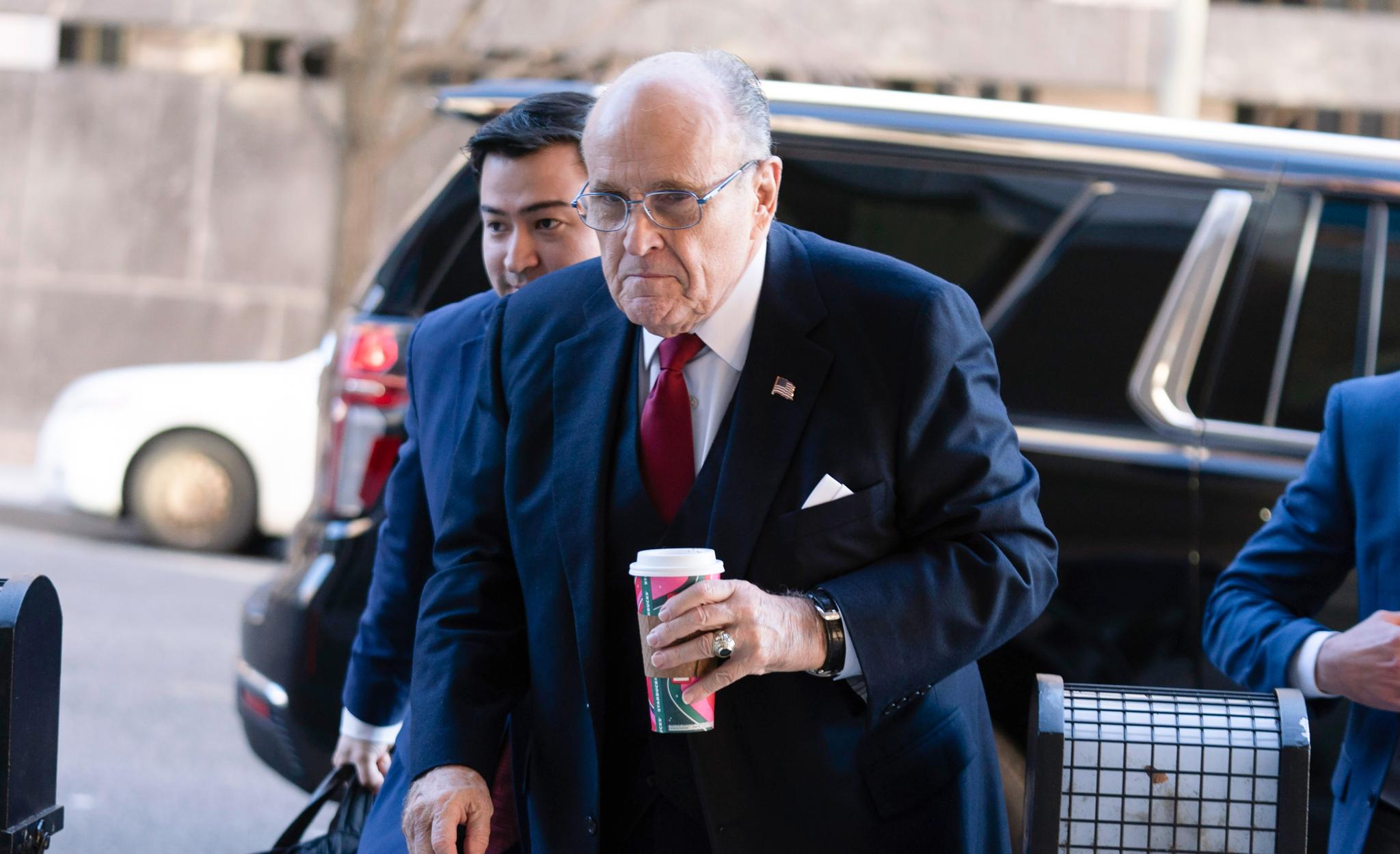 Rudy Giuliani with a venti Starbucks, blue suit and red tie