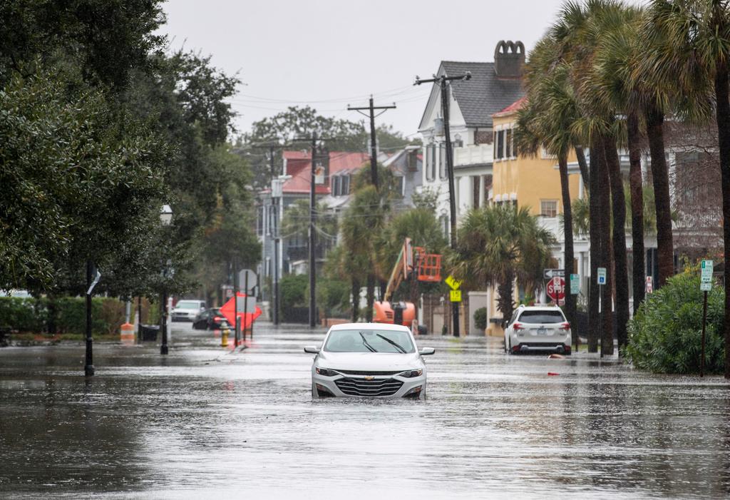 A car drives through a flooded street near the Battery in Charleston, S.C.