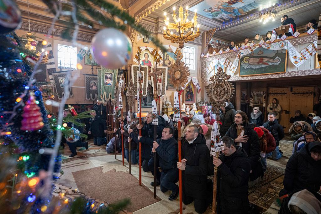 People pray in the church during Christmas celebration in Kryvorivnia village, Ukraine